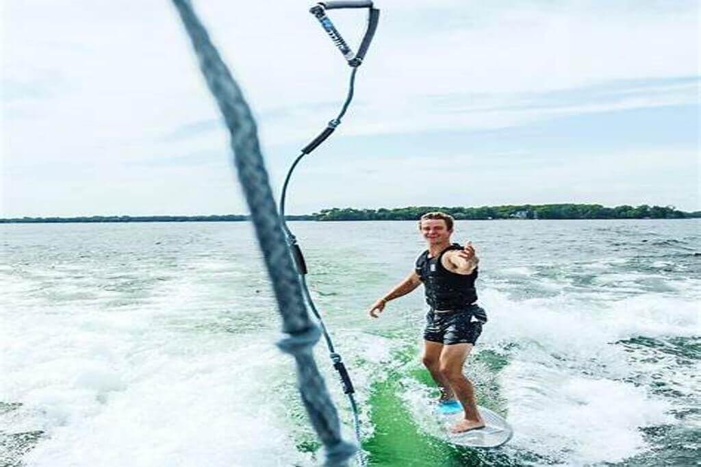 man in a padde board on a lake with rope