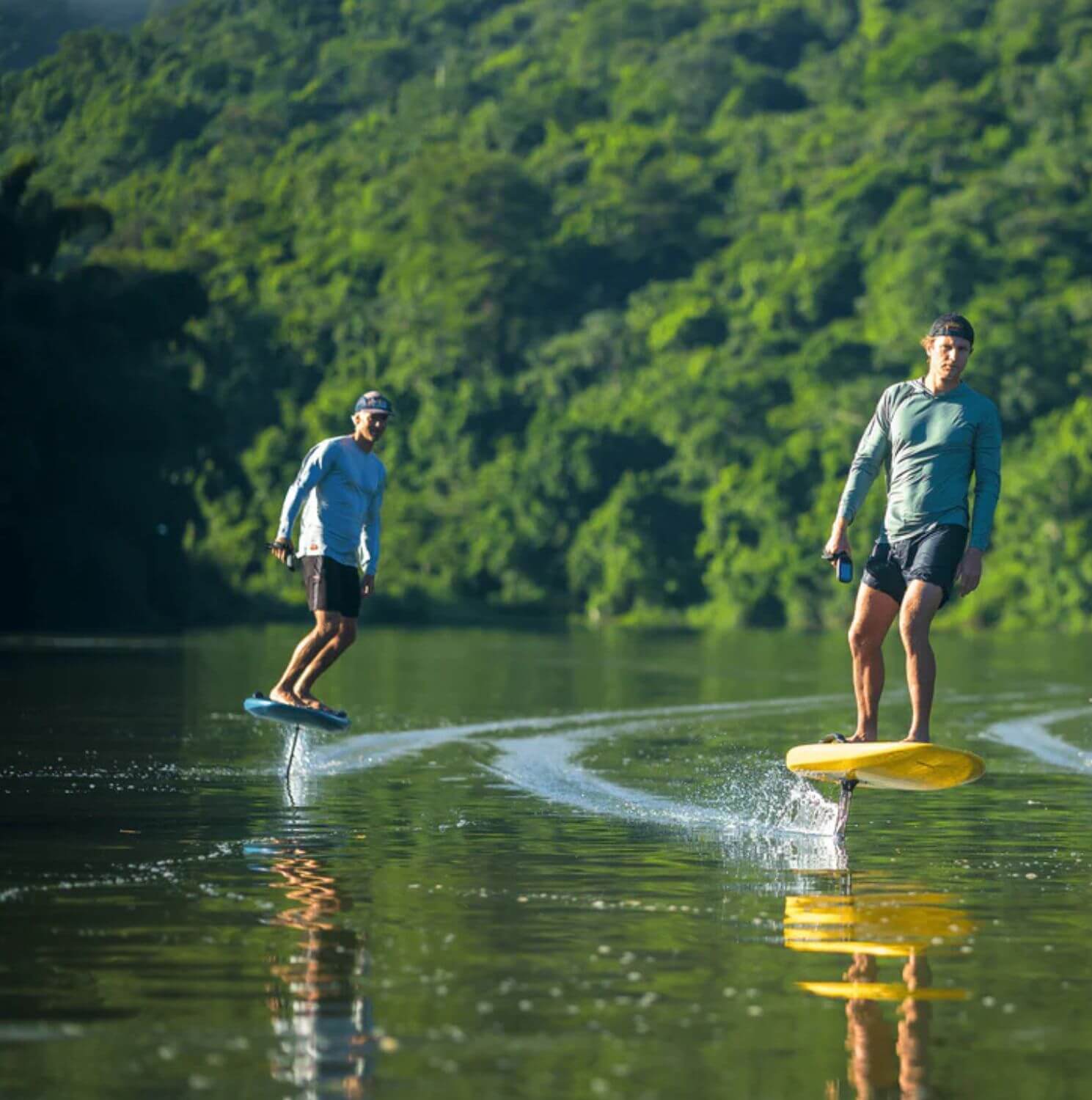 two man standing in the efoil board on the sea