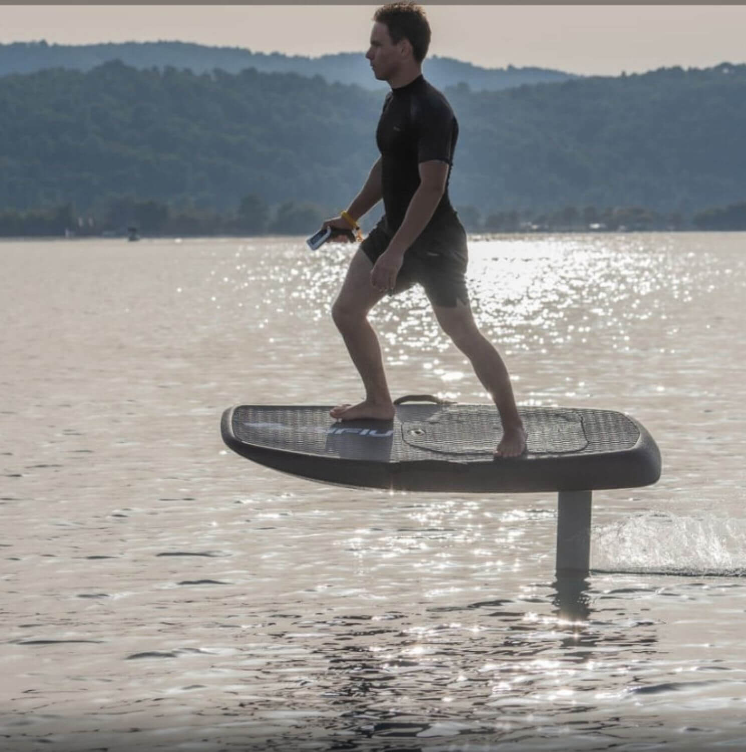 man standing on efoil board in the middle of the ocean